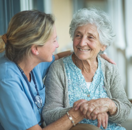 caregiver providing compassionate home health care support to an elderly woman during wound care in Kokomo, IN.
